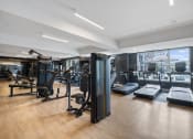 Thumbnail 26 of 61 - a gym with cardio machines and weights on a wooden floor