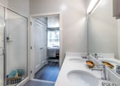 Thumbnail 44 of 53 - Modern bathroom with dual vanity and glass shower at Inwood at Renaissance Square Apartments, Marlton, New Jersey