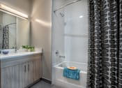Thumbnail 42 of 53 - Bathroom with wood vanity and tub shower combo at Inwood at Renaissance Square Apartments, Marlton