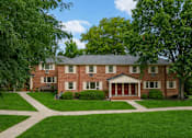 Thumbnail 11 of 14 - A large red brick house with a white front door.