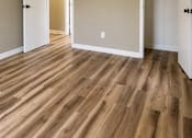 Thumbnail 6 of 14 - A room with a ceiling fan and wood flooring.