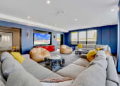 Thumbnail 12 of 35 - a living room with blue walls and couches and a television