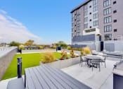 Thumbnail 22 of 35 - a patio with a table and chairs on a roof terrace with an apartment building