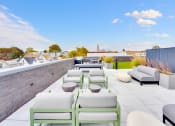 Thumbnail 26 of 35 - a rooftop terrace with couches and tables and a brick wall