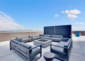Thumbnail 18 of 35 - a patio with couches and a fire pit on a roof