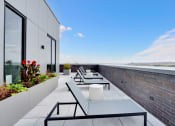 Thumbnail 21 of 35 - a rooftop terrace with tables and chairs and a brick wall