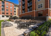 Thumbnail 35 of 80 - a patio with tables and chairs outside of an apartment building