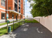 Thumbnail 39 of 80 - a fenced in area with a tennis court in front of a building