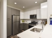 Thumbnail 42 of 80 - a kitchen with stainless steel appliances and white counter tops