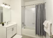 Thumbnail 68 of 80 - a bathroom with a shower and a sink and a mirror