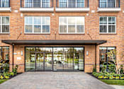 Thumbnail 52 of 53 - Building entrance with glass doors and covered canopy at Inwood at Renaissance Square Apartments, Marlton, NJ