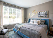 Thumbnail 37 of 53 - Bedroom with blue upholstered bed and neon wall art at Inwood at Renaissance Square Apartments, Marlton, 08053