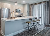 Thumbnail 33 of 53 - Kitchen island with bar seating and vertical window blinds at Inwood at Renaissance Square Apartments, Marlton, 08053