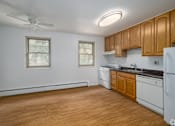 Thumbnail 3 of 5 - A kitchen with wooden cabinets and a white refrigerator.