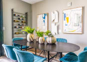 Thumbnail 35 of 44 - a dining room with blue chairs and a table with vases on it