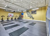 Thumbnail 19 of 80 - a yoga room with yoga mats on the floor and a yellow wall with bikes