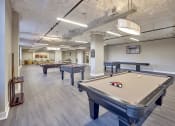Thumbnail 15 of 80 - two pool tables in a community room with other billiard tables