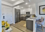 Thumbnail 43 of 80 - a kitchen and living room with stainless steel appliances and a white counter top