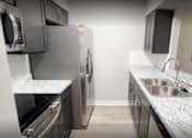 Thumbnail 10 of 11 - Modern renovated kitchen with stainless steel appliances, new cabinets, countertops, and luxury vinyl flooring in a 2-bedroom unit at Lynnhaven Landing