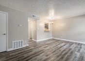Thumbnail 2 of 14 - an empty living room with wood flooring and white walls