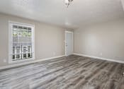 Thumbnail 9 of 14 - an empty living room with wood flooring and a window