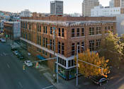 Thumbnail 5 of 26 - A street view of a city with cars and buildings.