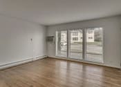 Thumbnail 15 of 18 - an empty living room with a large window and wooden floors