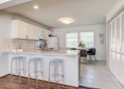 Thumbnail 3 of 18 - a kitchen with a bar and stools in front of a counter top