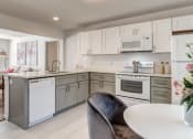 Thumbnail 5 of 18 - a white kitchen with white appliances and a table