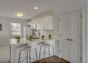 Thumbnail 11 of 18 - a white kitchen with bar stools and white cabinets