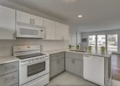 Thumbnail 12 of 18 - a white kitchen with a stove and a sink