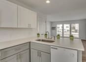 Thumbnail 13 of 18 - a white kitchen with a sink and white cabinets