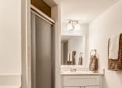 Thumbnail 8 of 18 - a bathroom with a shower and a sink and a mirror