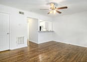 Thumbnail 1 of 12 - A room with a ceiling fan and wooden floors.