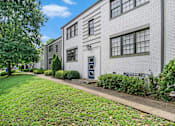 Thumbnail 8 of 12 - A white building with a blue door and windows.