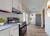 Thumbnail 2 of 22 - A kitchen with a stove top oven and a refrigerator.