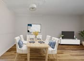 Thumbnail 11 of 22 - A dining room with a wooden table and white chairs.