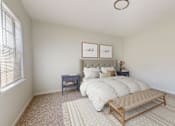 Thumbnail 15 of 22 - A bedroom with a bed, nightstands, and a bench.