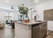 Thumbnail 29 of 46 - A modern kitchen with a granite countertop and stainless steel appliances.at The Liliana Apartment Homes, Pooler