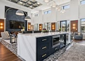 Thumbnail 14 of 46 - A modern kitchen with a large island and dark cabinets.at The Liliana Apartment Homes, Pooler