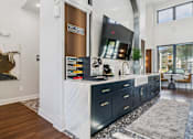 Thumbnail 24 of 46 - A modern kitchen with dark wood cabinets and a white countertop.at The Liliana Apartment Homes, Pooler Georgia