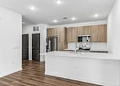 Thumbnail 61 of 124 - Modern kitchen with wood cabinetry and white island at Velara Luxury Apartments, Ponte Vedra Beach