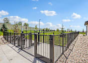 Thumbnail 17 of 24 - A black metal fence surrounds a paved area.