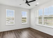 Thumbnail 57 of 124 - Bright empty bedroom with ceiling fan and windows at Velara Luxury Apartments, Florida