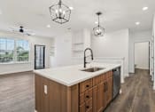 Thumbnail 3 of 62 - A kitchen with a white countertop and wooden cabinets.
