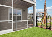 Thumbnail 55 of 124 - Screened patio with artificial turf and metal railing at Velara Luxury Apartments, Ponte Vedra Beach, Florida
