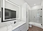 Thumbnail 57 of 60 - A modern bathroom with a white sink and a walk-in shower.