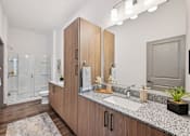 Thumbnail 33 of 43 - A bathroom with a sink, mirror, and a plant at The Hadley - North Port, FL Apartments, North Port, FL, 34287