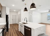 Thumbnail 68 of 105 - A modern kitchen with a white countertop and dark wood flooring. at The Pullman Luxury Apartments, Atlanta, Georgia