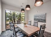 Thumbnail 34 of 57 - A conference room with a long table and chairs, a plant, and a painting on the wall at The Stadler Luxury Apartments, Bradenton, 34210